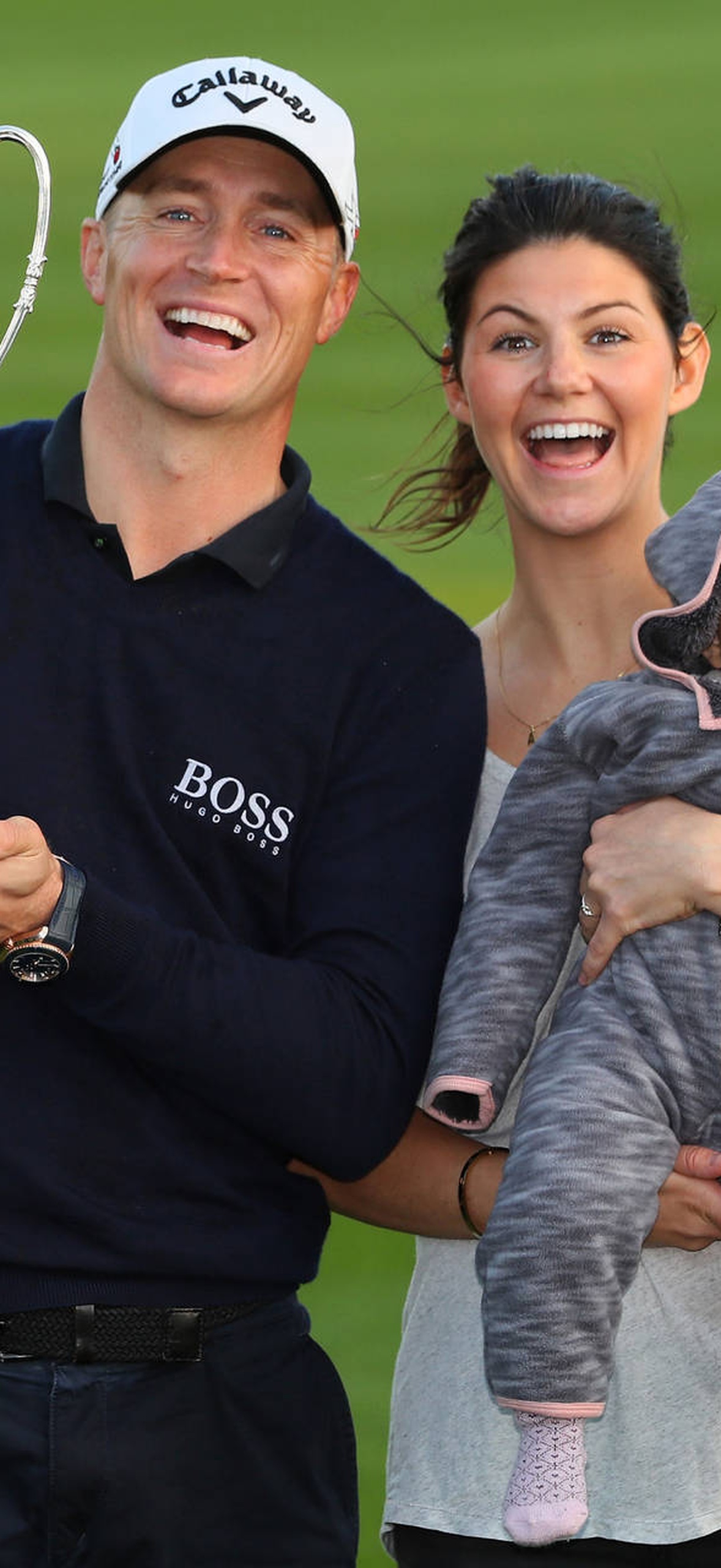 Golfer and family celebrating victory with trophy on golf course