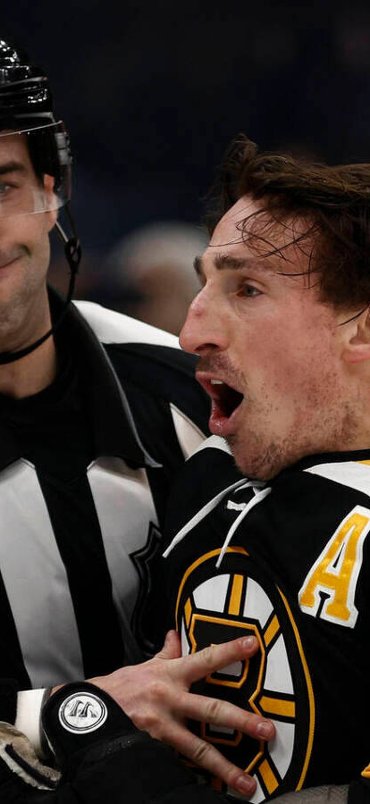 Hockey player hugging referee after a play.