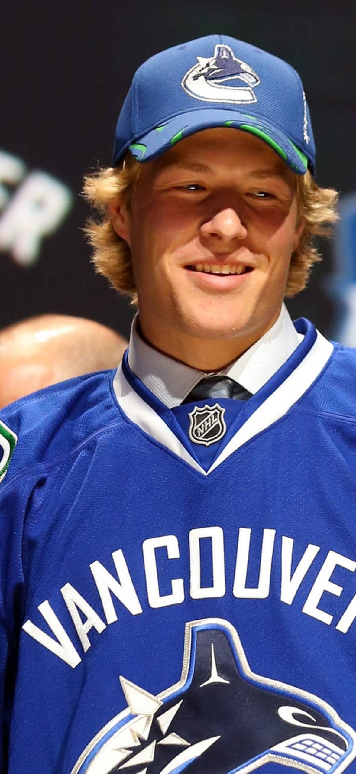 Young hockey player in Vancouver Canucks jersey at draft event