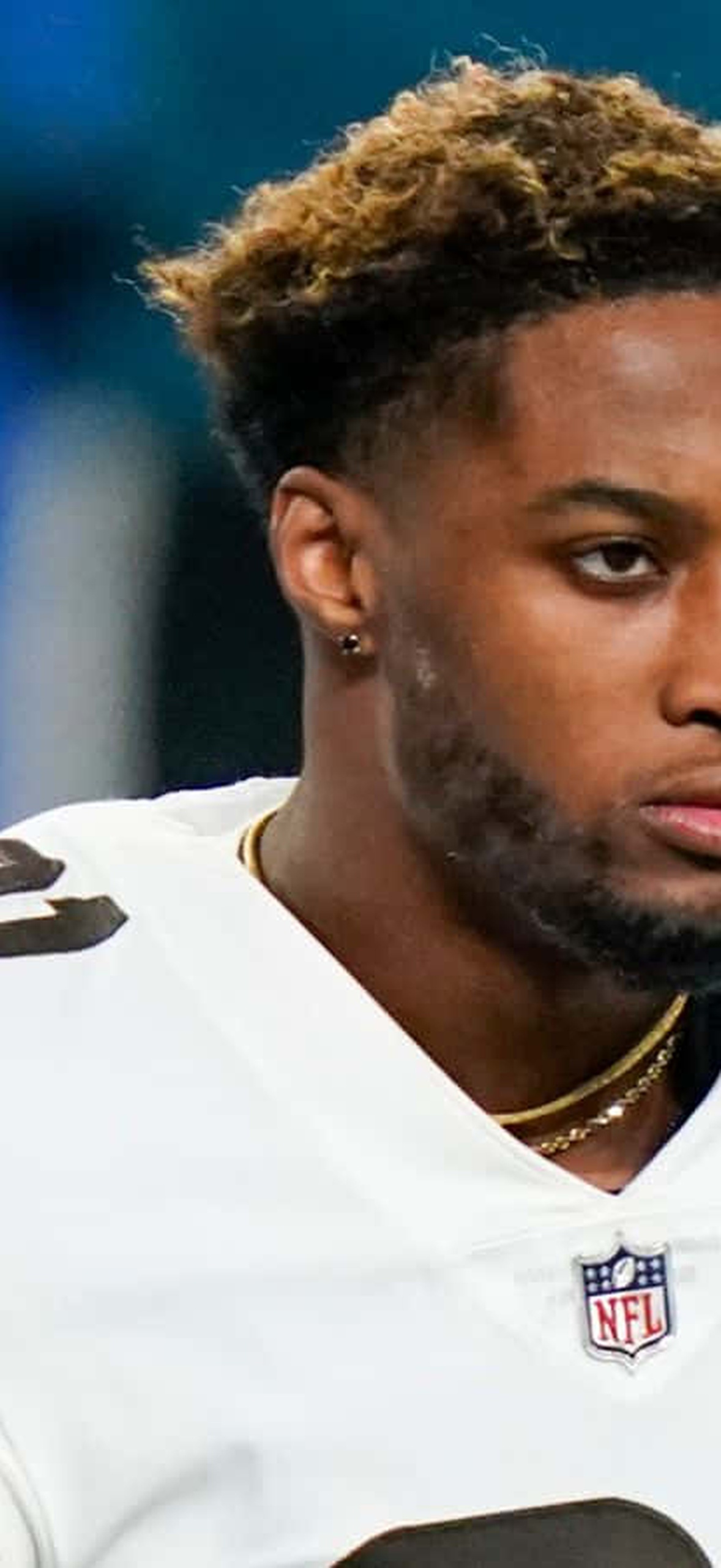 Cleveland Browns football player in white jersey with orange and brown stripes looking focused.
