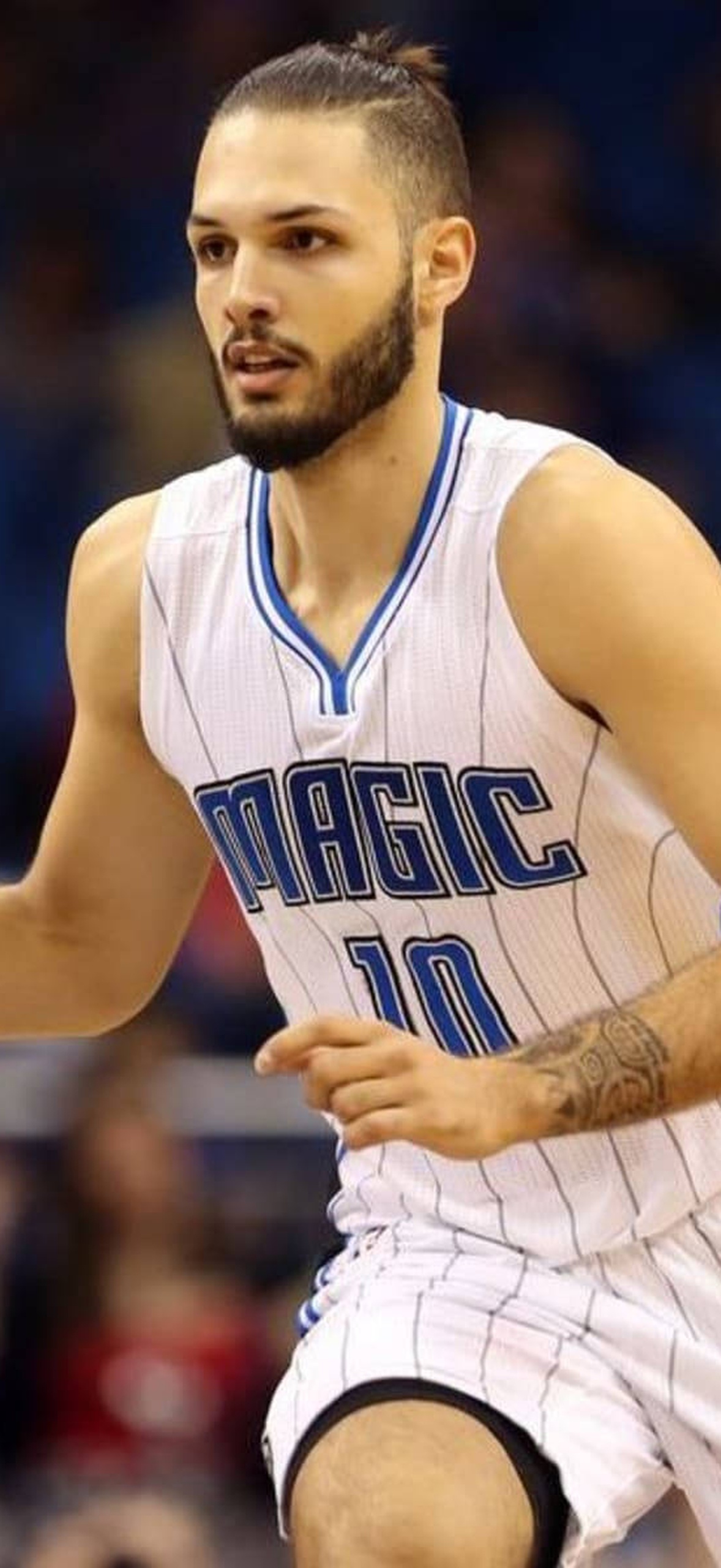 Basketball player dribbling during a game in an arena.