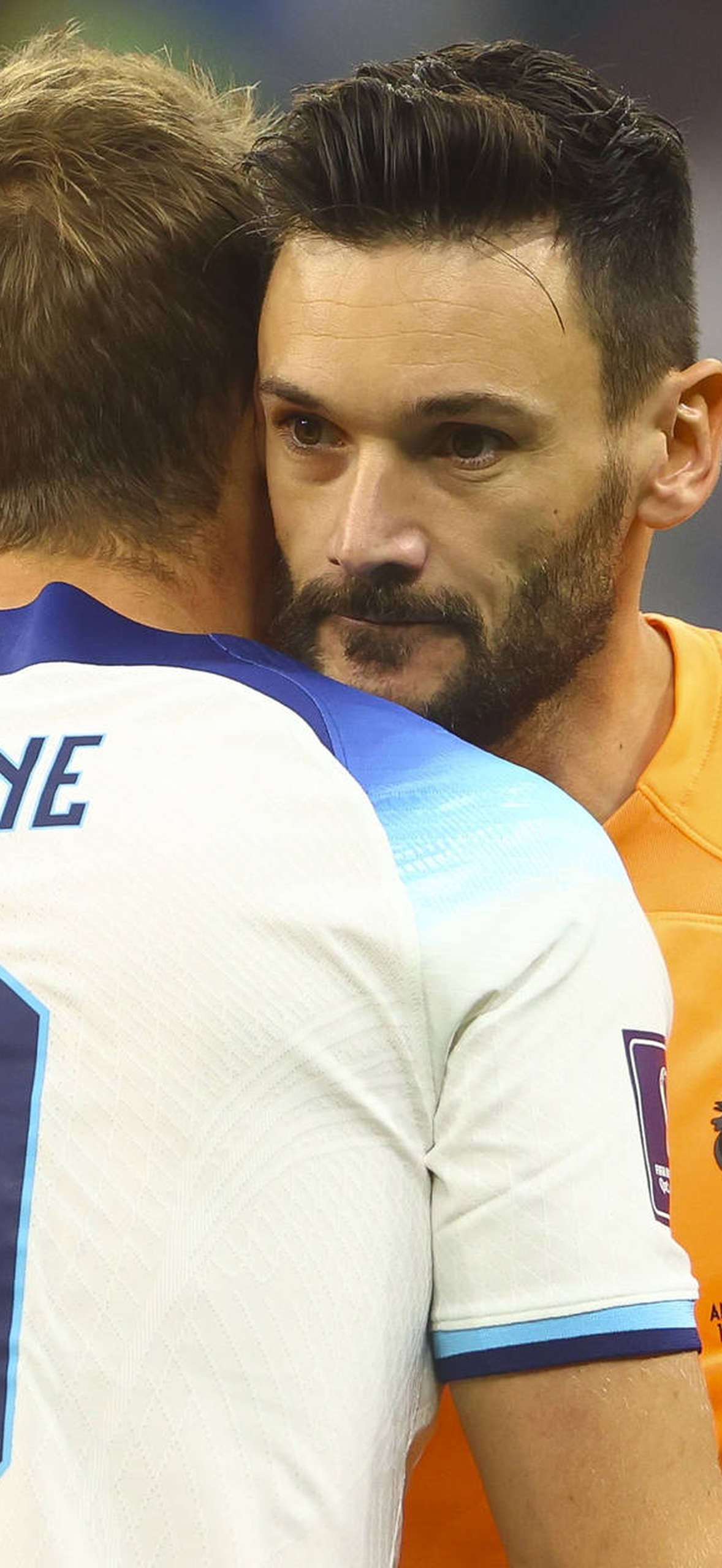 Soccer goalkeeper hugging player Kane after a match.