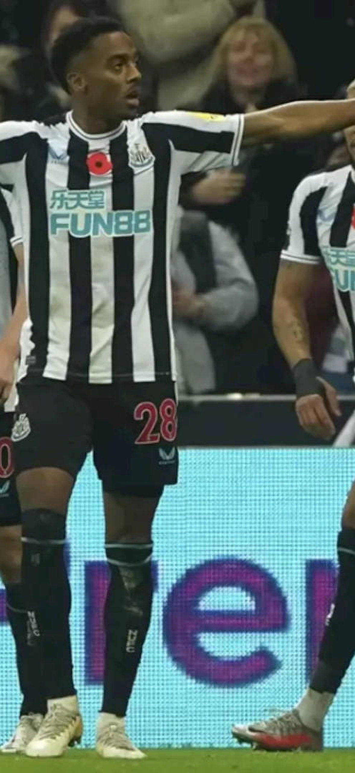 Newcastle United footballers celebrate a goal during a night match.