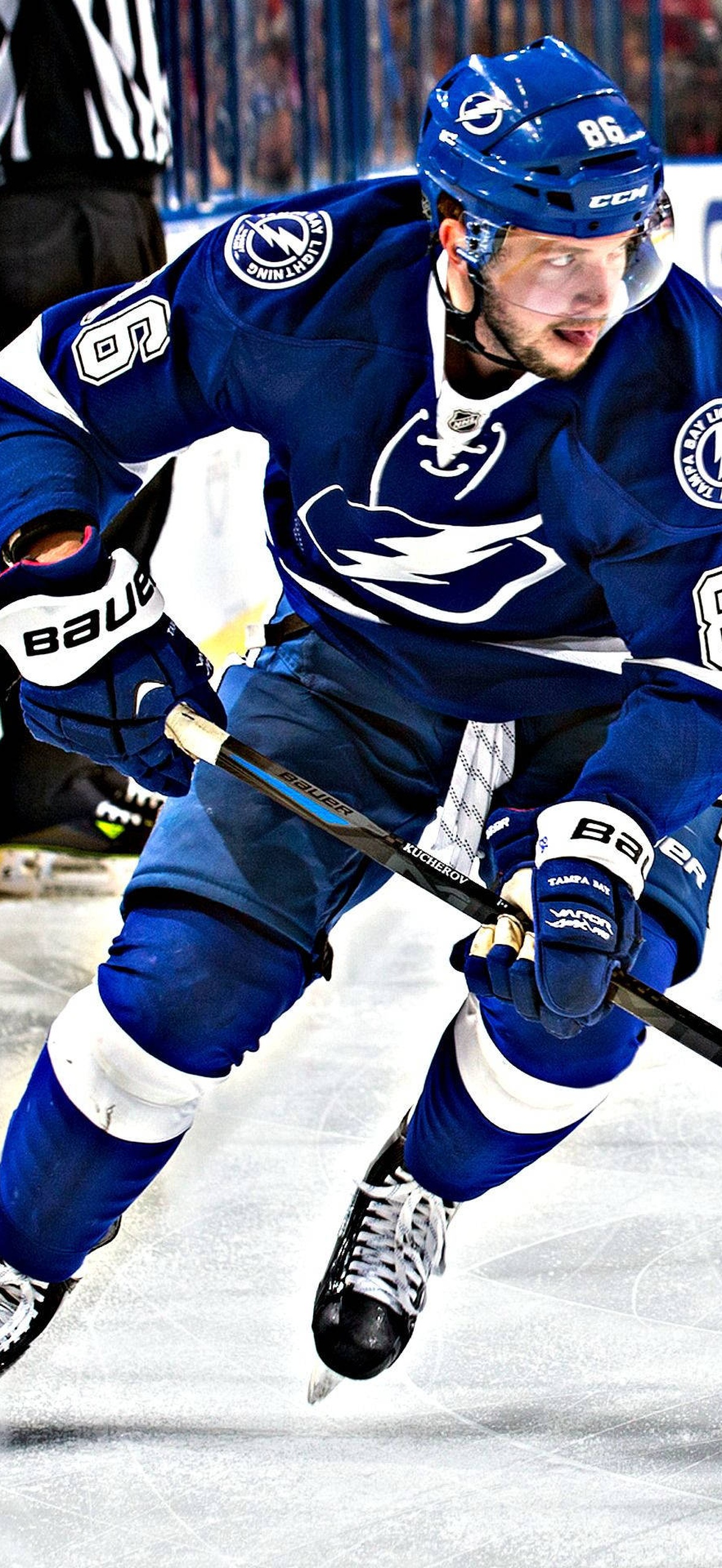 Hockey player in blue uniform skating on ice during game.
